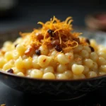 A creamy bowl of payasam with macaroni, garnished with cashews, raisins, and saffron.