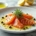 Salmon crudo final dish with garnished salmon slices, olive oil drizzle, and microgreens on a white plate.